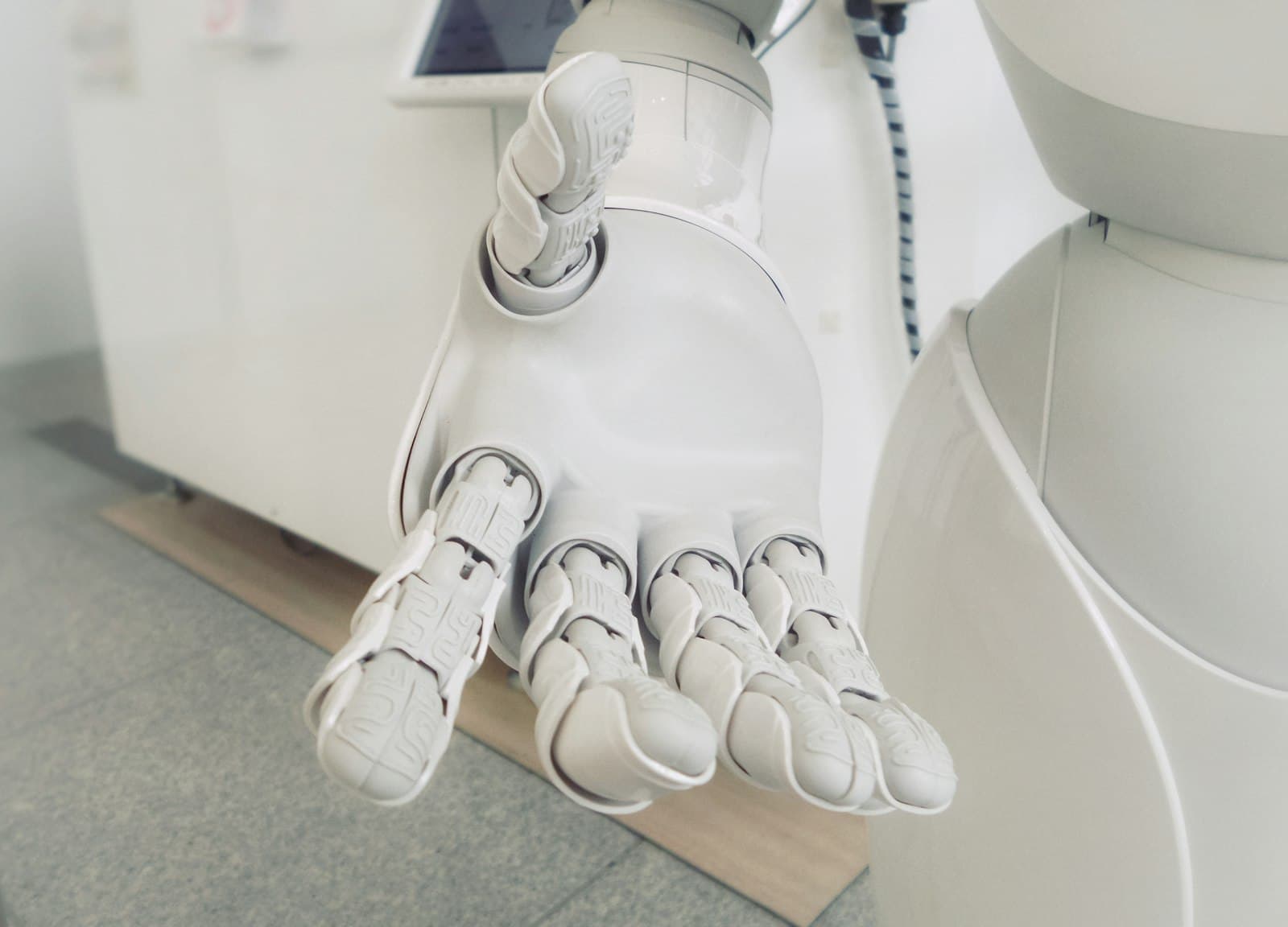 Open white robotic hand reaching towards the viewer